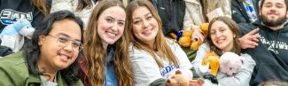 A row of students sitting in the stands at a U N E hockey game